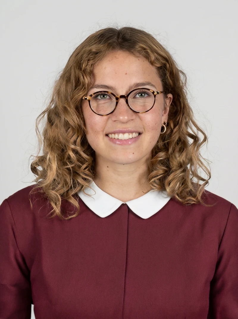 Restored portrait, Nano Banana Pro: burgundy blouse, cool gray studio backdrop, slimmer and smoother face than the input