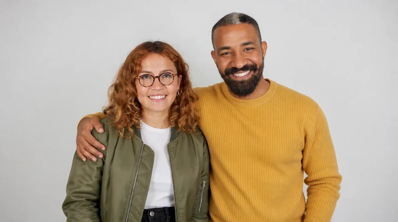 AI-generated test image of two fictional adults, our test character and our second test character: the GPT Image 2 result, both in frame to the hips, his arm around her shoulders, slightly smooth skin, light-gray studio backdrop